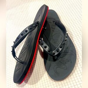 Black flip flop sandals with red bottoms. Barely worn